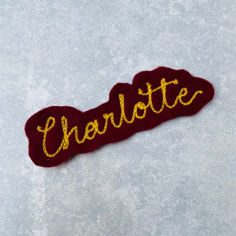Custom vintage chain stitch name patch in burgundy and yellow.