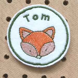 Embroidered name patch with fox design.