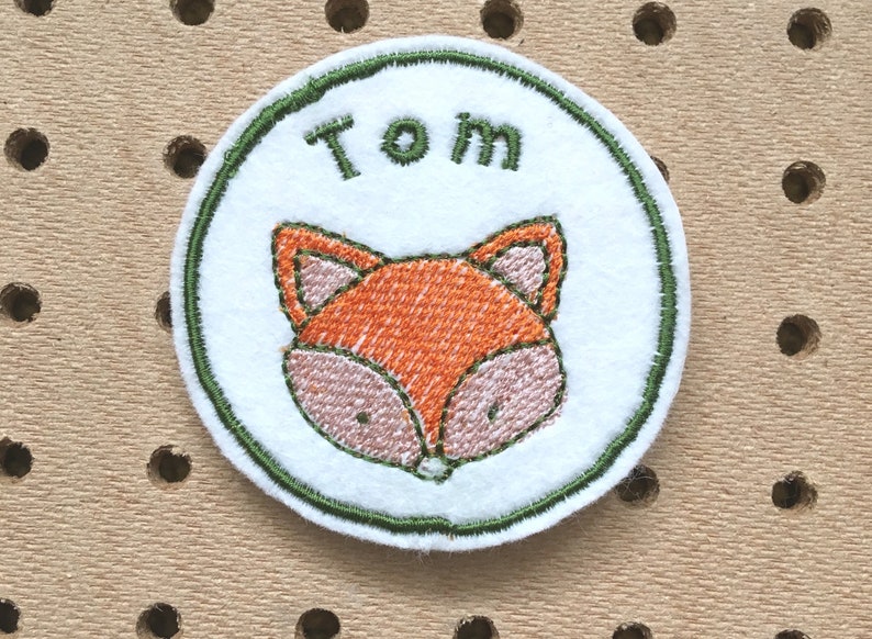 Embroidered name patch with fox design.