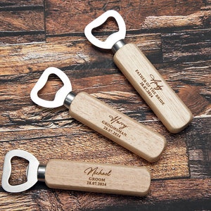 May include: Three wooden bottle openers with engraved text. The top opener says "Harry Father of the Bride 28.07.2024". The middle opener says "Harry Groomsman 28.07.2024". The bottom opener says "Michael Groom 28.07.2024".