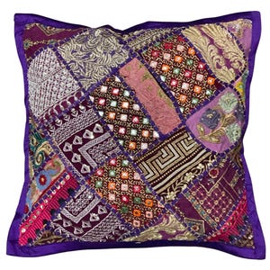 Pode incluir: Capa de almofada de patchwork roxo com bordados intrincados e lantejoulas. A capa de almofada é feita de vários tecidos em tons de roxo, rosa e dourado.