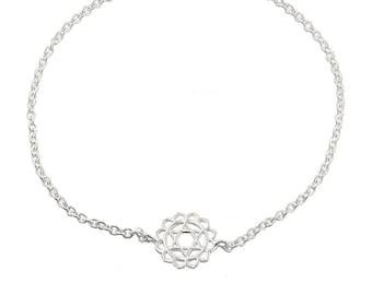 May include: A silver chain bracelet with a delicate silver charm featuring a geometric design. The charm is a symbol of the Anahata chakra, the heart chakra.