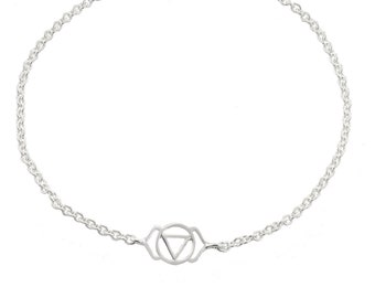 May include: A silver-colored bracelet featuring a delicate chain and a central charm with a geometric design. The charm consists of a circle with a triangle inside. The bracelet has a lobster clasp closure and an adjustable chain.