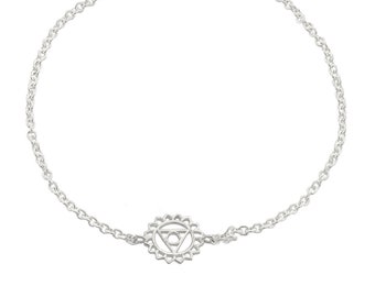 May include: A silver chain bracelet with a silver charm featuring a stylized chakra symbol.