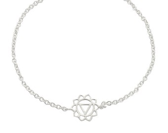 May include: A silver chain bracelet with a delicate charm featuring the Anahata chakra symbol, a stylized lotus flower with a triangle inside.