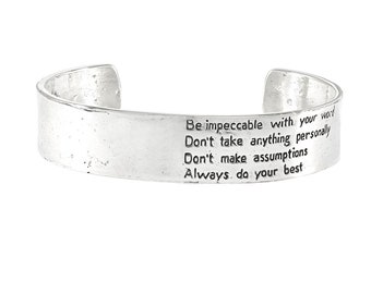 May include: Silver bracelet with an inspirational quote engraved on it: "Be impeccable with your word. Don't take anything personally. Don't make assumptions. Always do your best."