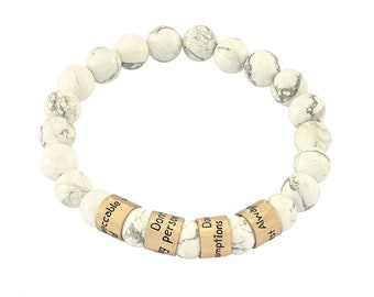 May include: White Howlite beaded bracelet with gold-toned metal beads engraved with the words "Unacceptable", "Don't", "Being", "Person", "Don't", "Assumptions", "Always", "First".
