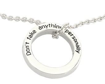 May include: Silver necklace with a circular pendant that reads "Don't take anything personally".