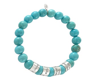 May include: Turquoise beaded bracelet with silver charm and engraved silver beads. The beads are engraved with the words "Be in your world", "Don't be afraid", "Make a difference", "Stay strong", and "Be your own kind of beautiful".