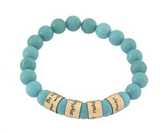 May include: Turquoise beaded bracelet with gold charms that have inspirational messages: "Be in", "your wor", "anythin", "make", "it", "alway".