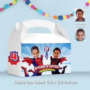 May include: White gable box with a handle, featuring a superhero theme. The box has a blue sky background with two children dressed as superheroes. Text on the box reads "RYDER & HAYES AMAZING FRIENDS". The box label measures 6.2 x 3.5 inches.