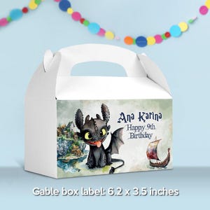 May include: White gable box with a cartoon dragon illustration. The box label reads "Ana Karina Happy 9th Birthday" and includes a Viking ship graphic. The box measures 6.2 x 3.5 inches.