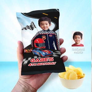 May include: A black and white chip bag with a racing theme. The bag features a child wearing a racing suit and a red and blue race car. The text "Gabe's 4th Birthday" is printed on the bag.