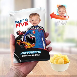 May include: A personalized bag of potato chips with a racing theme. The bag features a child's photo, race cars, and the text "FAST & FIVE" and "JEFFREY'S 5TH BIRTHDAY". A small bowl of chips sits next to the bag.