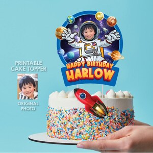 Puede incluir: Topper de pastel imprimible con un niño vestido de astronauta en una escena espacial azul y negra con planetas y estrellas. El topper dice "Happy Birthday Harlow".