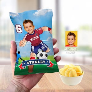 May include: A personalized chip bag with a cartoon image of a boy playing soccer. The bag is green and blue with a white star and the text "Stanley" on it. The boy is wearing a red and blue jersey with the number 16 on it. The bag is a great way to celebrate a birthday or special occasion.