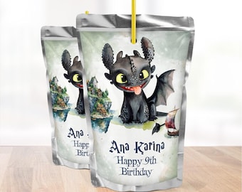 May include: Two juice boxes with a cartoon dragon illustration. The dragon is black with large yellow eyes and a red tongue. The boxes have a silver top and a yellow straw. Text on the boxes reads "Ana Karina Happy 9th Birthday."