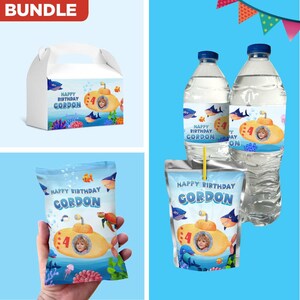 May include: A bundle of birthday party supplies featuring a yellow submarine design. Includes a white gable box, water bottles, juice pouches, and a snack bag. Each item has the text "HAPPY BIRTHDAY GORDON" and a picture of a child.