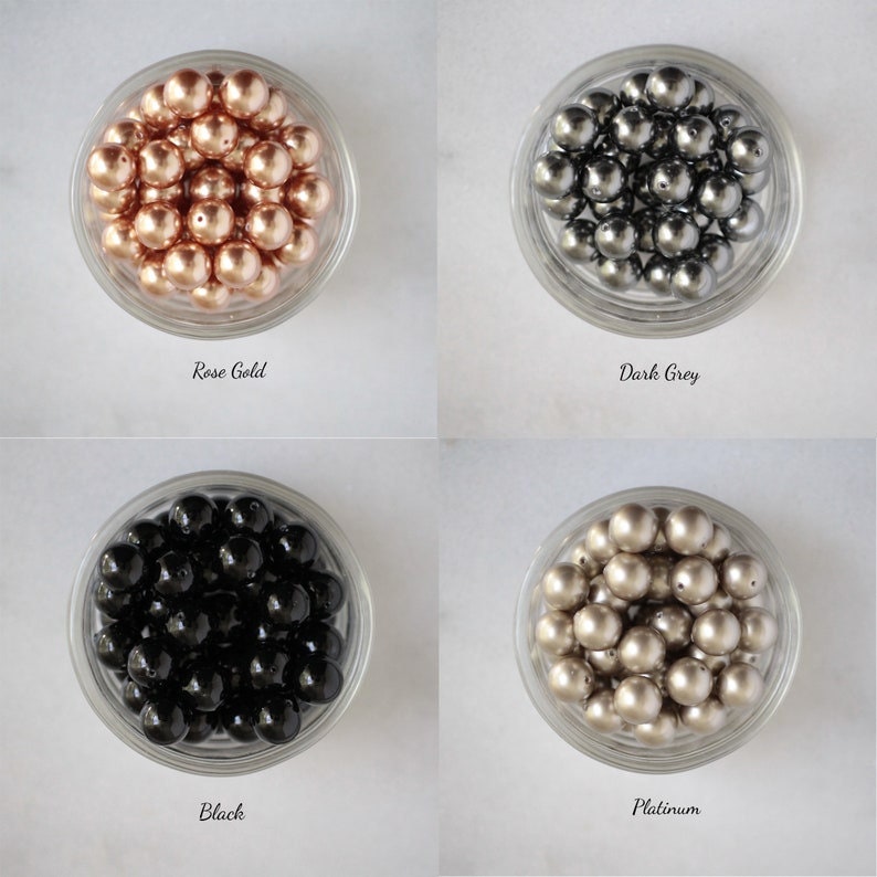 May include: Four bowls of pearl-like beads in different colors: rose gold, dark grey, black, and platinum.