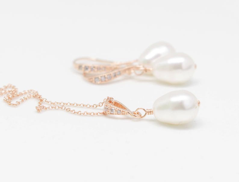 May include: A set of rose gold earrings and a necklace with pearl accents and crystal embellishments.