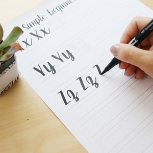 Pu&ograve; includere: Una mano che scrive le lettere "1212" su un foglio di carta rigato con un pennarello nero. La carta ha le parole "Simple beginner" e "Yy Yy" scritte su di essa.