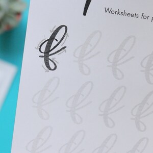 May include: A black and white worksheet with the letter 'f' written in cursive. The worksheet has multiple lines for practicing writing the letter 'f'.