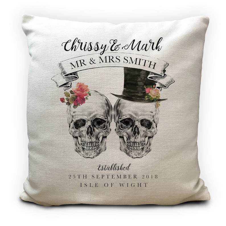 May include: A white cushion with a black and white illustration of two skeletons wearing a top hat and flowers. The text on the cushion reads "Chrissy & Mark MR & MRS SMITH established 25TH SEPTEMBER 2018 ISLE OF WIGHT".