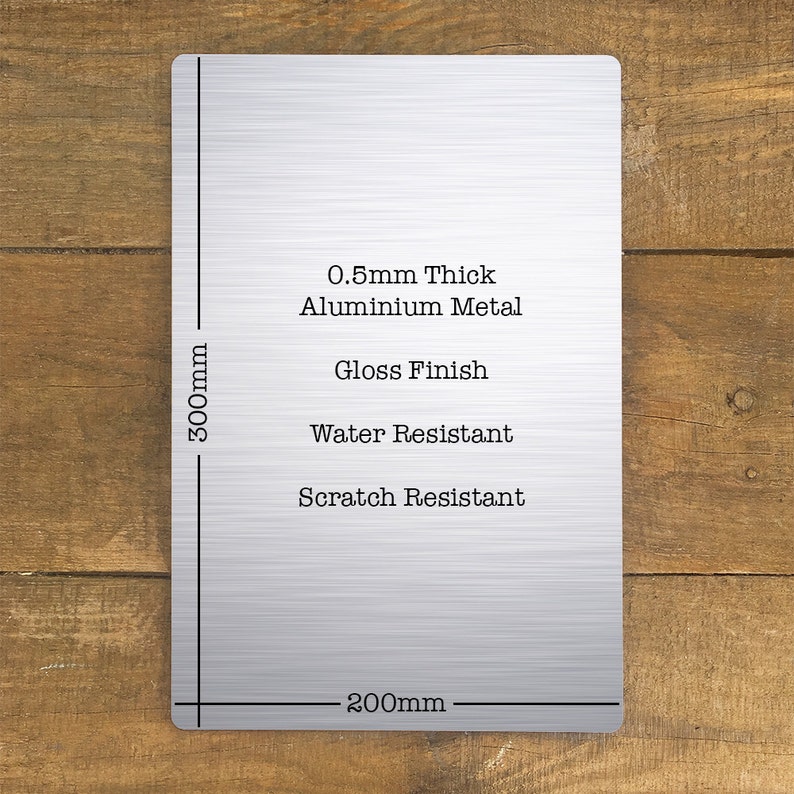 Pu&ograve; includere: Un cartello in metallo argentato con il testo "0.5mm Thick Aluminium Metal, Gloss Finish, Water Resistant, Scratch Resistant". Il cartello &egrave; largo 200 mm e alto 300 mm.