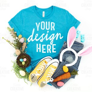 MOCKUP - Bella Canvas Heather Aqua Blue 3001 T-Shirt Flat Lay Easter Mockup Jeans, Pastel Shoes, Eggs, Bunny Ears on White Background JPEG