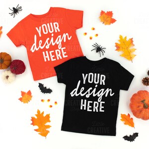 May include: Two blank t-shirts, one orange and one black, with the text "Your design here" on each. The shirts are surrounded by fall leaves, candy corn, pumpkins, and bats.