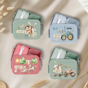 May include: Four colorful lunchboxes with different animal and farm themes. Each lunchbox has a name on it: Julian, Anton, Laura, and Lukas. The lunchboxes are made of durable plastic and have a built-in fork.