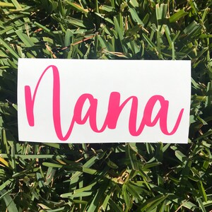 May include: A white vinyl sticker with the word "Nana" written in pink cursive lettering.