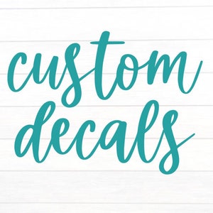 May include: Turquoise script lettering on a white, wood-grain background. The words "custom decals" are written in a flowing, cursive font. The image is a simple, clean design, perfect for advertising custom decal services.