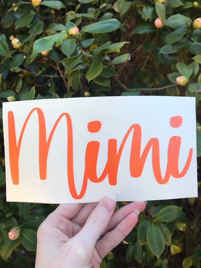 May include: Orange vinyl decal with the word "Mimi" written in a cursive font.