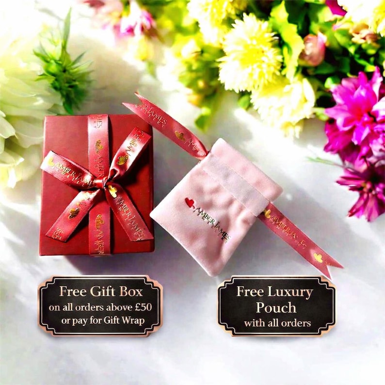 a red gift box with a red ribbon, placed on a table with a bouquet of flowers in the background. There are two signs in the image, one indicating a free gift box and the other offering a free luxury pouch with all orders above £50 or paying for a gift wrap.