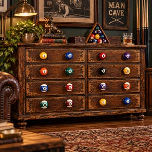 May include: A dark brown wooden dresser with a distressed finish featuring eight drawers. Each drawer is fitted with two round billiard ball knobs, numbered one through fifteen, arranged in numerical order across the drawer fronts.