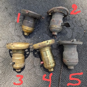 May include: Five antique brass light bulb sockets with different styles and designs. Some have a switch on the side.