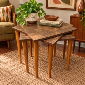 May include: A set of three nested wooden tables with square tops featuring a parquet pattern and tapered legs. A white planter with a black starburst design holds a green plant, and two books titled The Mid-Century Home and Retro Living.