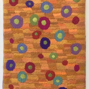 May include: A colorful rug with a textured background and a pattern of circles in various colors, including red, green, blue, purple, and yellow.