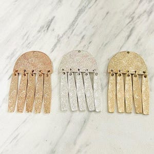 May include: A set of three ceramic mugs with a speckled, matte finish. The mugs are in shades of cream, light gray, and dark gray. Each mug has a simple, minimalist design, perfect for coffee or tea.