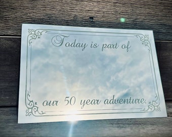 May include: A silver plaque with a decorative border and the text "Today is part of our 50 year adventure."