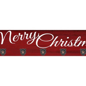 May include: Red wooden sign with the text "Merry Christmas" in white cursive lettering. The sign has six metal hooks.