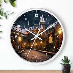 May include: White round clock with a black and white image of a castle with lights and snow. The clock face has black numbers and hands.