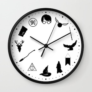 Puede incluir: Un reloj blanco y negro con marco negro y esfera blanca. El reloj presenta varios iconos temáticos de Harry Potter, incluyendo un cartel de la plataforma 9 3/4, un Sombrero Seleccionador, una Snitch Dorada y un símbolo de las Reliquias de la Muerte.