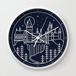 May include: A white clock with a black face featuring a line drawing of Hogwarts castle against a starry night sky. The clock hands are white.