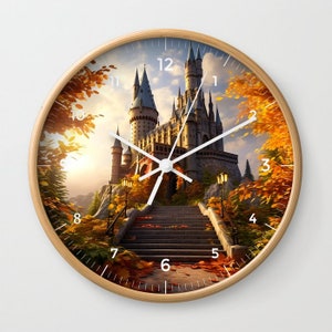 May include: A round wooden clock with a white face and black Roman numeral hour markers. The clock face features a picture of a fairytale castle with a stone staircase leading up to the entrance. The castle is surrounded by trees with autumn leaves.