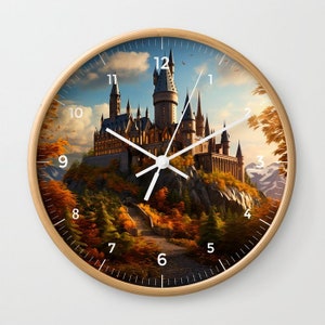 May include: A round clock with a wooden frame and a white face. The clock face features a picture of a castle with a forest in the foreground. The numbers 1 through 12 are printed on the clock face.