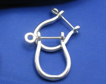 May include: A pair of silver-toned earring backs. The backs are shaped like a horseshoe with a screw-on closure.