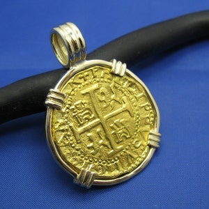 May include: Gold coin pendant featuring a cross design with intricate details. The coin is set in a silver bezel and has a bail for attaching to a chain.