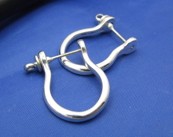 May include: A pair of silver earring findings with a hook closure. The findings are in the shape of a U and are designed to be used with other jewelry components.